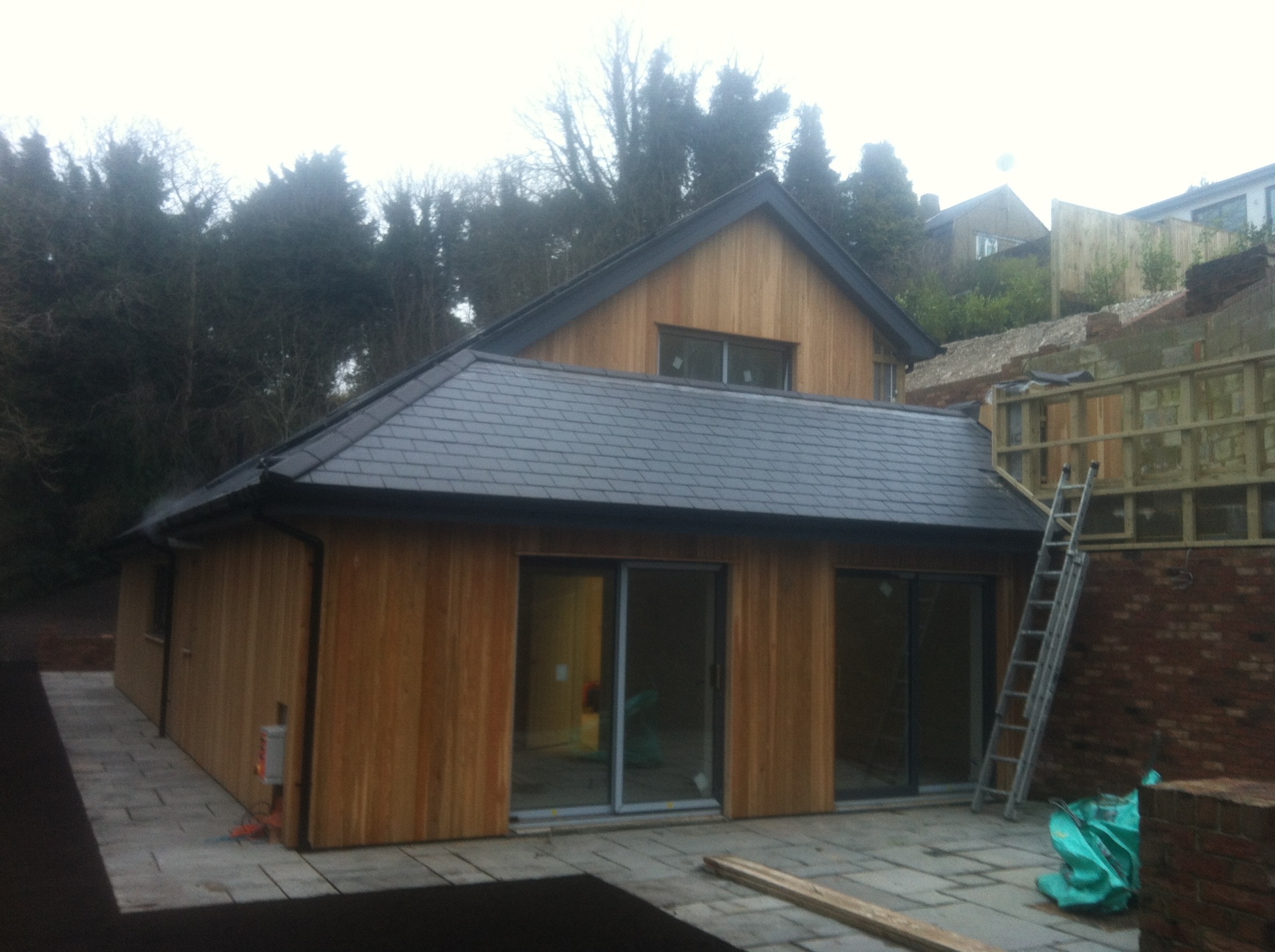 Indian sandstone patio with raised planting beds and turfed lawn